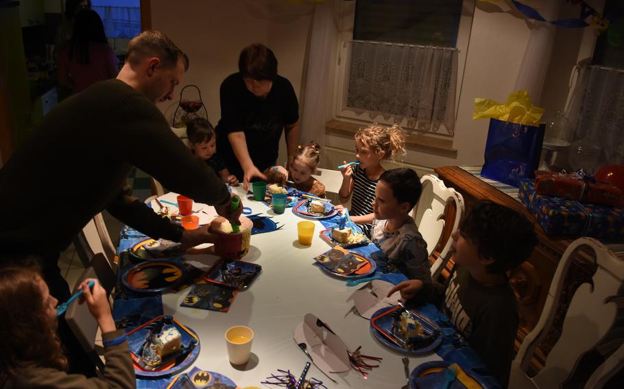 Maj. Devon Bledsoe, an Air Force officer assigned to Ramstein Air Base, Germany, dishes out ice cream at a birthday party for a Ukrainian boy staying with his family in the village of Queidersbach, March 16, 2022. An extended family of seven is staying with the Bledsoes until they can get settled in a new home in Germany.