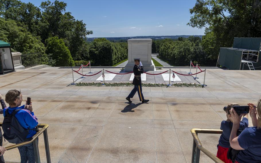 Spectators watch the guard march past the tomb,