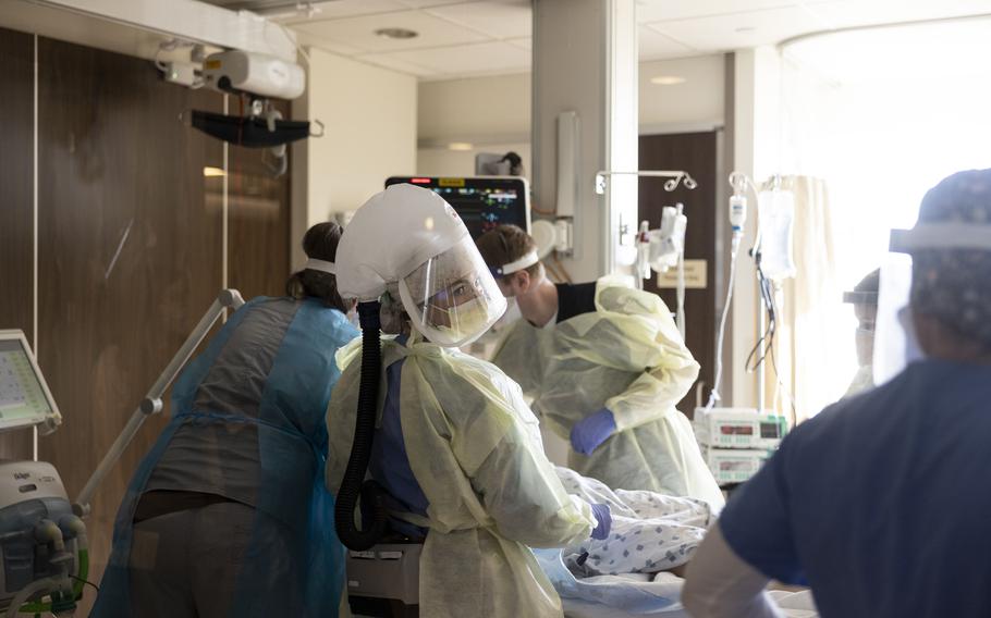 A team of nurses and physicians transfers a patient with COVID-19 into an ICU room at CentraCare-St. Cloud Hospital in St. Cloud, Minn.