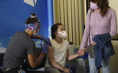San Diego, CA - May 25: At Rady Children&apos;s Hospital on Wednesday, May 25, 2022 in San Diego, CA., Samara Winkler, 9 held her mother&apos;s Jennie Lapoint hand as Jillian Mercer gave her the COVID booster vaccination. (Nelvin C. Cepeda / The San Diego Union-Tribune)