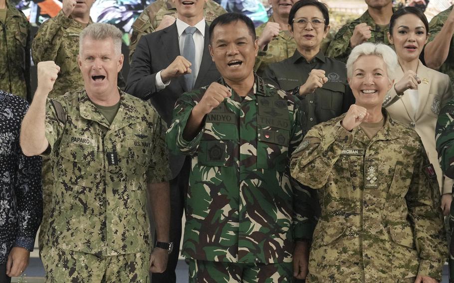 Service members make a fist and yell together.