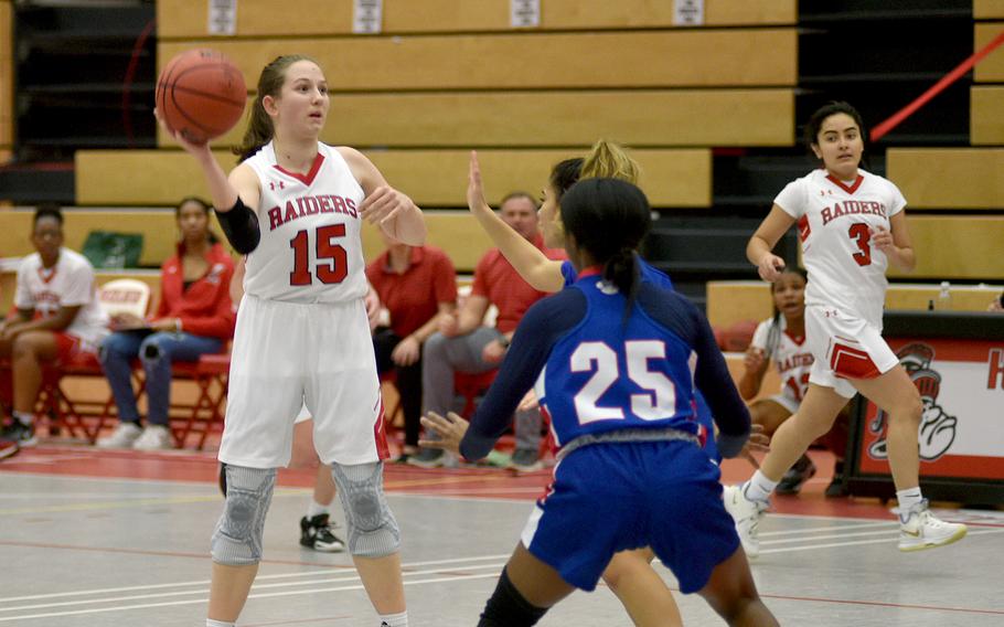 Kaiserslautern's Elizabeth Marriott, left, looks to pass as Ramstein's Bralyn Jones defends on Tuesday evening at Kaiserslautern High School,  Germany. In the background right is the Raiders' Kimberly Guzman.