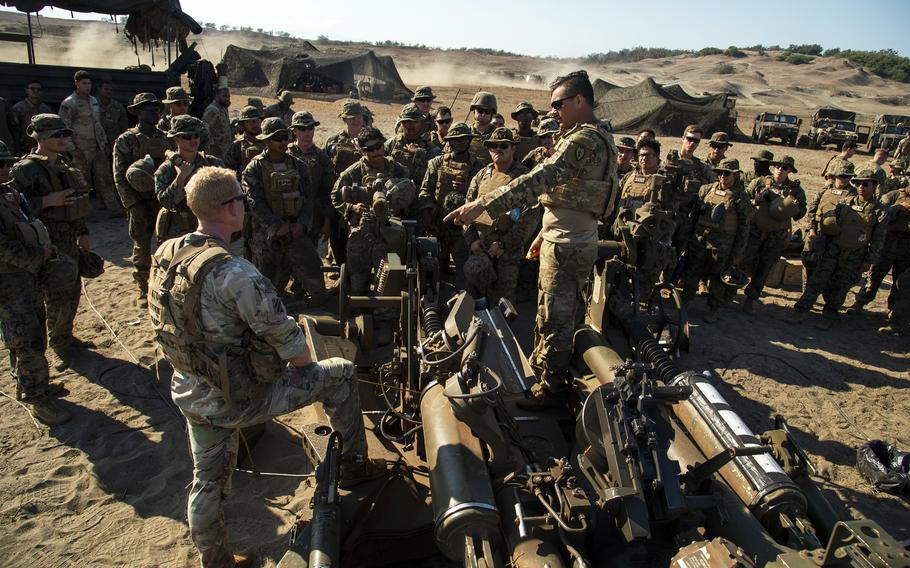 A soldier with the 7th Field Artillery Regiment speaks to Marines and sailors about the M-777 howitzer during a Balikatan drill at the La Paz Sand Dunes in Laoag, Philippines, May 6, 2024.