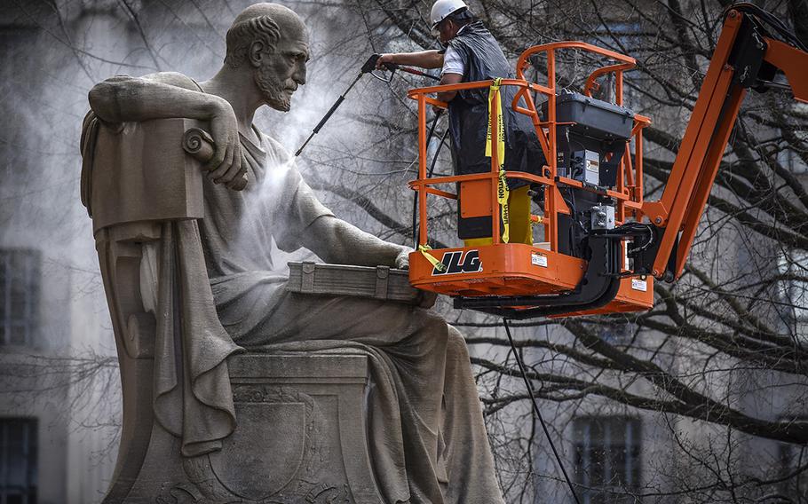 Contractors give a spring cleaning to Robert Aitken's statue from 1935 of Socrates, located on the Pennsylvania Avenue side of the National Archives in Washington, on April 4, 2017. 