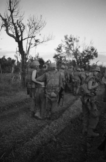 Wounded marines of the 1st Battalion, 9th Marines — supported by their battle buddies — march back to the command post after fighting back the NVA. Some men were blinded in the ambush and had to be carried. 