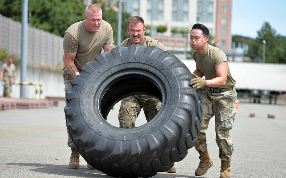 From left, Tech. Sgt. Matthew Waldeck, Senior Airman Jake Stallone and Staff Sgt. Joseph Park, from Incirlik Air Base, Turkey’s 728th Air Mobility Squadron, flip a tire during the endurance event at the Port Dawg Rodeo at Ramstein Air Base, Germany, July 6, 2022.