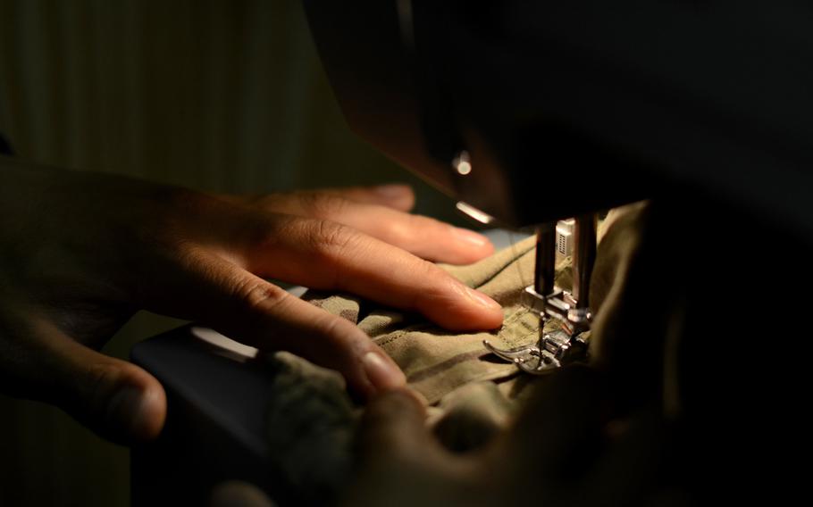 Sgt. Wilfredo Briones patches up a ripped pair of pants. Briones takes care of his platoon by stitching up uniforms and cutting their hair at Combat Outpost Sabari.