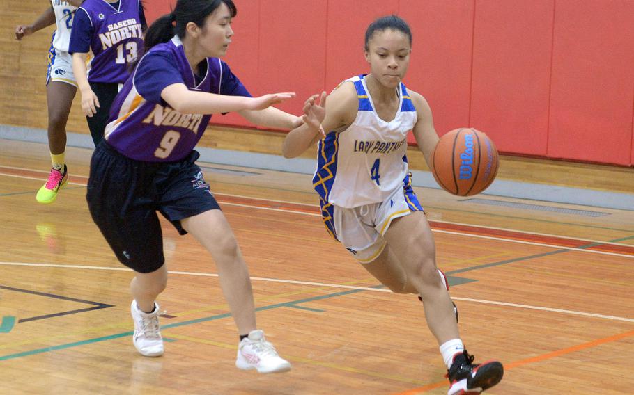 Yokota's Coco Jones dribbles against Sasebo North's Tsukasa Watanabe during Saturday's Japan girls basketball game. The Panthers won 63-48.