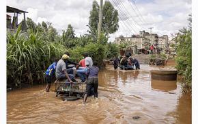 Residents cross floodwater in the Githurai district of Nairobi. MUST CREDIT: Patrick Meinhardt/Bloomberg