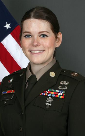 Allison Ravelli poses in uniform with an American flag in the background.