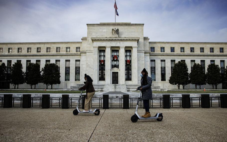 Visitors ride electric scooters near the Marriner S. Eccles Federal Reserve building in Washington, D.C., on Nov. 20, 2021. 