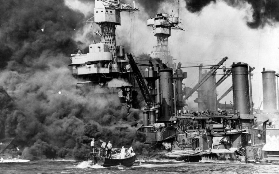 Sailors in a motor launch rescue a survivor from the water alongside the sunken USS West Virginia on Dec. 7, 1941.