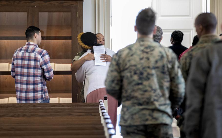 Petitfrere hugs parishioners after services at the United States Marine Corps Memorial Chapel in Quantico.