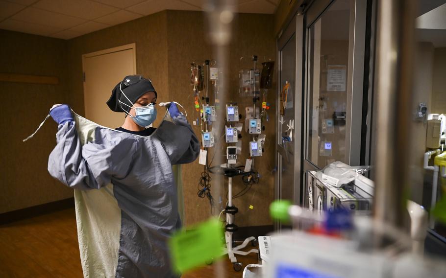 North Memorial Health Hospital Critical Care Nurse Kayla Lynch wears a protective gown before entering the room of a COVID-19 patient during her shift Monday, Dec. 7, 2020 in Robbinsdale, Minn. Hospitals in Michigan and Minnesota on Tuesday, Nov. 16, 2021, reported a wave of COVID-19 patients not seen in months as beds were filled with unvaccinated people and health care leaders warned that staff were being worn down by yet another surge.