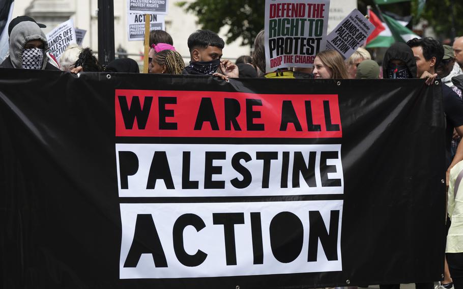 Demonstrators hold up a banner during a protest by Palestine Action group in London, Monday, June 23, 2025. 