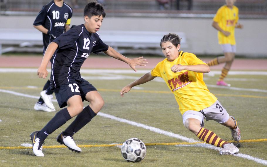 Zama’s Leon Phillips and Matthew C. Perry’s Shayden Torres scuffle for the ball during Friday’s DODEA-Japan boys soccer match. The Trojans won 2-1.