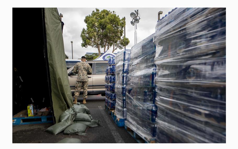 A U.S. Marine hands out fresh water at the Halsey Terrace community center on Honolulu, Hawaii, on Dec. 14, 2021.
