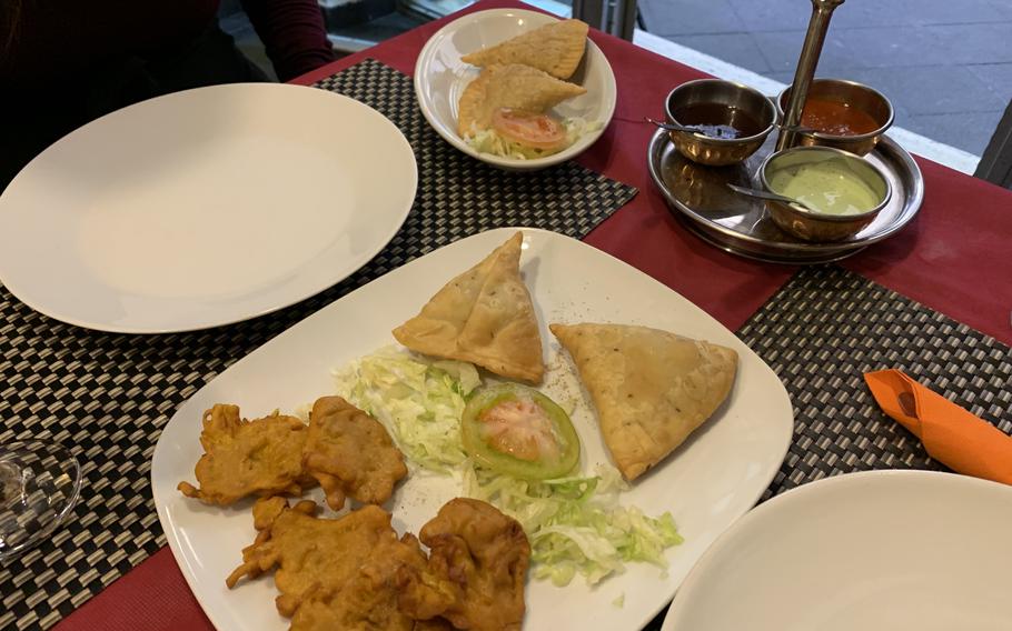Appetizers at Taj Mahal in Naples, Italy are priced from 3 to 7 euros and include traditional favorites such as vegetable fritters and samosas. Clockwise from left are onion bhaji pakora, vegetable samosas and chicken samosas.