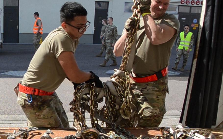 Senior Airman Gerald Dinio, left, and Airman 1st Class Matthew Lagrange of the 726th Air Maintenance Squadron out of Spangdahlem Air Base, lift chains onto a cart during the 721st Aerial Port Squadron Multi-Capable Airmen Rodeo at Ramstein Air Base on July 23, 2021. 