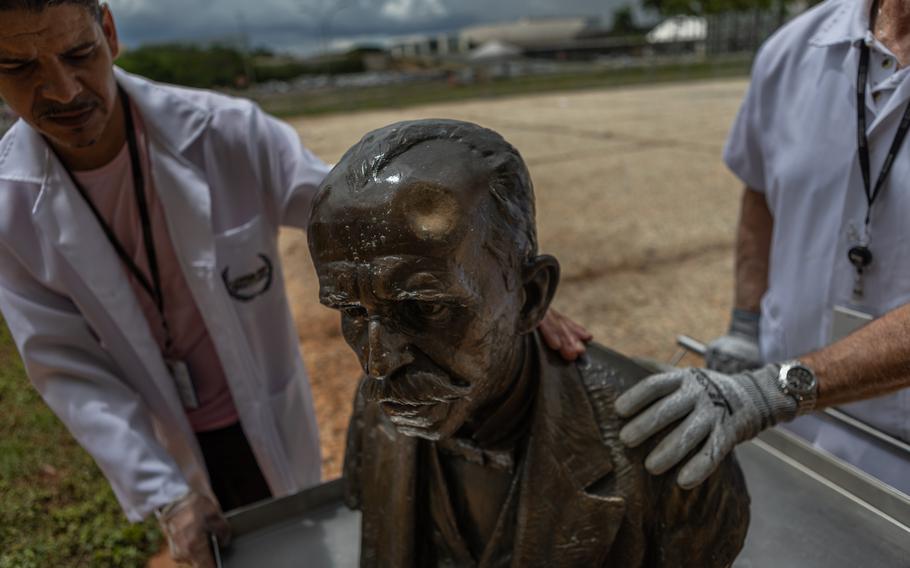 Marcos Faria and his team, responsible for conserving art in the Supreme Court's collection, removes the damaged sculpture of jurist Rui Barbosa for restoration. 