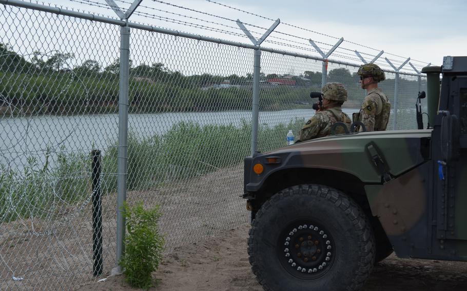 Texas National Guard troops watch for illegal activity along the Rio Grande near Eagle Pass, Texas, in May 2022. The troops are among about 5,000 on state orders at the border with Mexico. Another nearly 4,000 troops on federal orders are also serving along the border. 