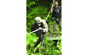 Okinawa, Japan, July 27, 2007: Lance Cpl. Joshua Rodriguez, 22, from Fredricksburg, Va., an administrative clerk with Marine Air Control Group 18, pulls himself across a rope bridge Friday at Commando Crawl, one of 31 obstacles on the endurance course at the Jungle Warfare Training Center on Camp Gonslaves.  "It was a challenge, but I'm always up for a challenge," said Rodriguez of the experience.

Read the full article and see additional stories here. https://www.stripes.com/news/camp-gonsalves-jungle-warfare-training-center-is-back-1.67061

META TAGS: Jungle Warfare Training; USMC; U.S. Marine Corps; Jungle Skill Course; 