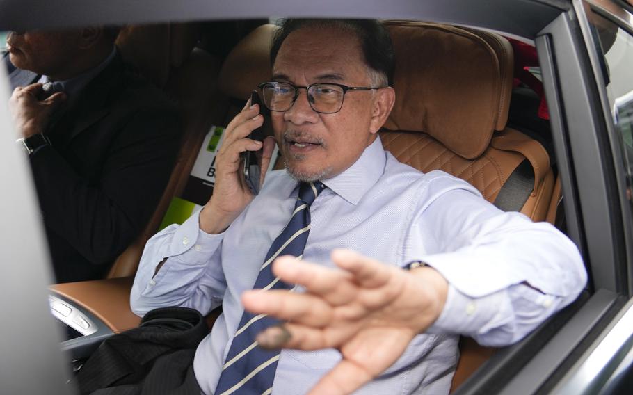 Opposition leader Anwar Ibrahim, talks on a phone as he leaves his office in Kuala Lumpur, Malaysia, Tuesday, Nov. 22, 2022. Malaysia’s election uncertainty deepened Tuesday after a political bloc refused to support either reformist leader Anwar Ibrahim or rival Malay nationalist Muhyiddin Yassin as prime minister, three days after divisive polls produced no outright winner.