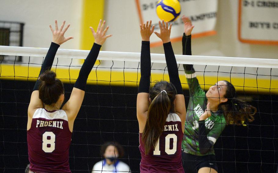 Kubasaki's Sophia Grubbs spikes against Seisen's Lisa Purcell and Aina Sekido.