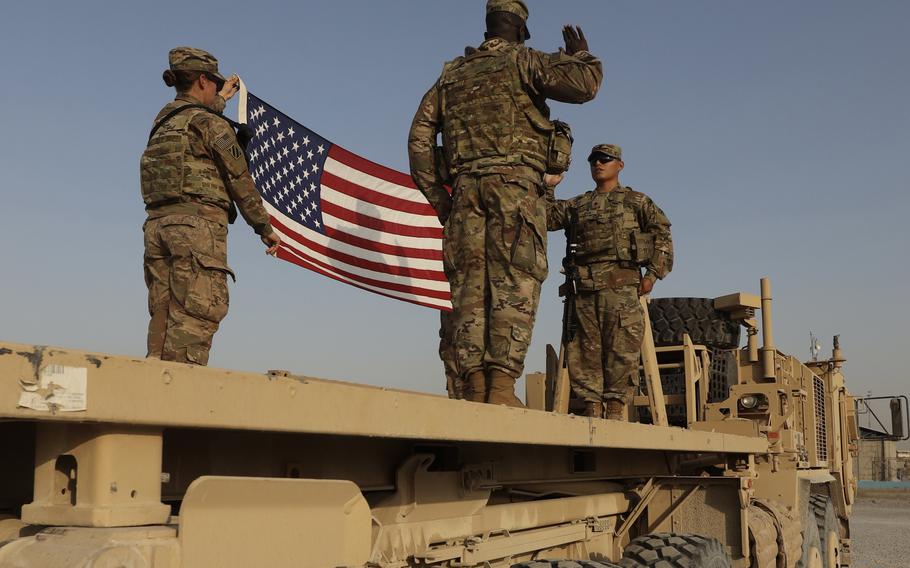 Spc. Manuel Leiva, right, with the 3rd Division Sustainment Brigade, raises his right hand and recites the oath of enlistment administered by Chaplain (Cpt.) Philibert Meyor, during a ceremony at Erbil, Iraq, Aug. 12, 2021. The Army is reducing soldiers' reenlistment window from 15 months before the end of the contract to 12 months.