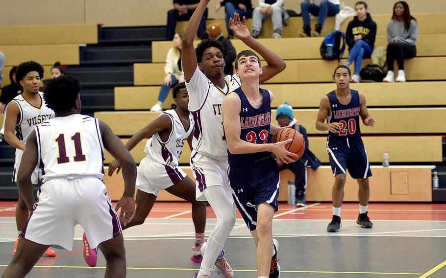 Lakenheath's Brendan Corwin drives to the bucket as Vilseck's Barkale Johnson defends during Saturday's basketball game at Kaiserslautern High School in Kaiserslautern, Germany. The Falcons won, 57-18.