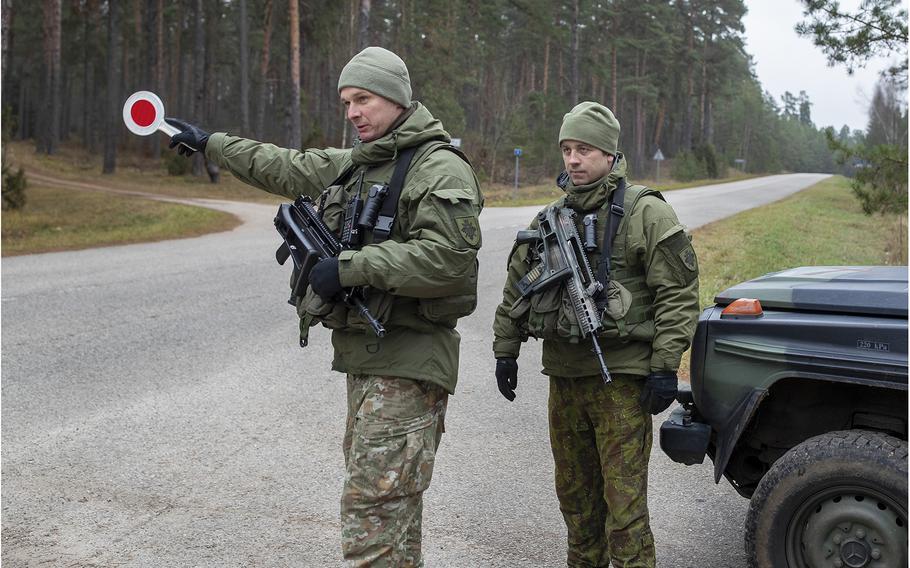 Lithuanian soldiers patrol a road near the Lithuania-Belarus border in November 2021.