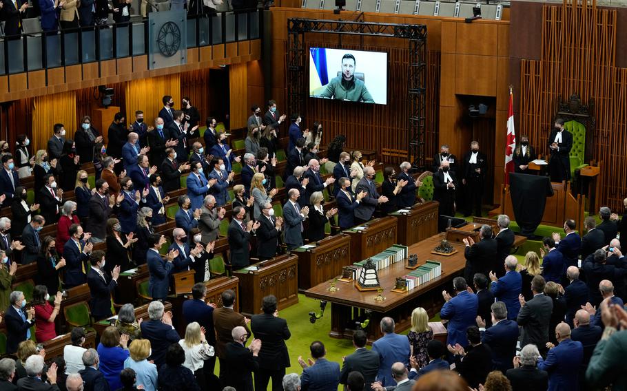 Ukrainian President Volodymyr Zelenskyy receives a standing ovation as he appears via videoconference to make an address to Parliament, in the House of Commons on Parliament Hill in Ottawa, on Tuesday, March 15, 2022.