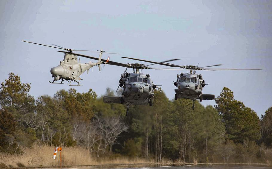 Two MH-60S Sea Hawk helicopters assigned to Helicopter Sea Combat Squadron 22, the “Sea Knights”, and one MQ-8B Fire Scout unmanned aerial vehicle conduct hover checks prior to a training flight at  at NASA Goddard’s Wallops Flight Facility on Feb. 24, 2020.