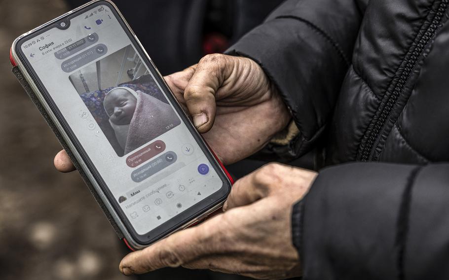 Maria Kamianetska, shown on Nov. 25, 2022, in Novosolone, Ukraine, holds a phone showing a photo of her newborn son, Serhii, that she sent to Vitalii Podlianov, the boy’s father, after he was born on Nov. 21. Serhii was killed when a missile hit a hospital in Vilnyansk on Nov. 23, 2022.