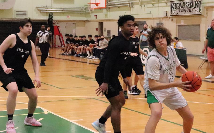 Kubasaki's Brodie Romnek looks to score against Zion Christian's Khalil Bowman while Zachary Bingham closes in on the action.