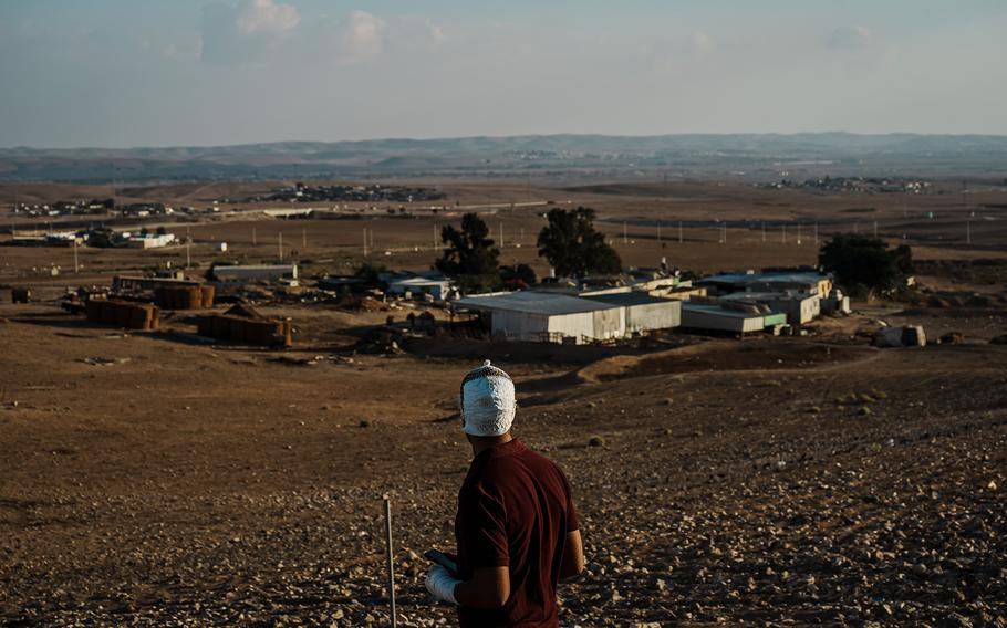 Adel abu Sbayeh looks over the Bedouin village of Al Bat and listens to an F-35 from a nearby Israeli military base heading to the Gaza Strip. On Oct. 7, 2023, a rocket that Abu Sbayeh is sure was meant for the base five miles away hit his house as his family gathered for breakfast.