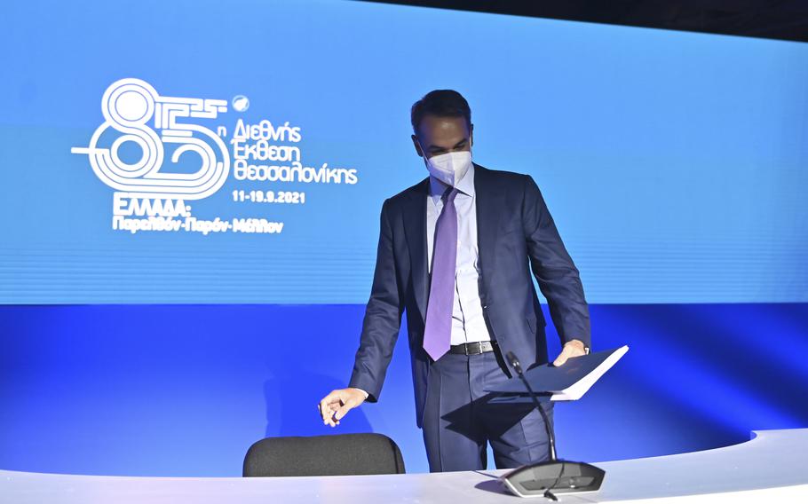Greece's Prime Minister Kyriakos Mitsotakis takes his seat for a news conference at the Thessaloniki International Fair, in the northern city of Thessaloniki, Greece, Sunday, Sept. 12, 2021.