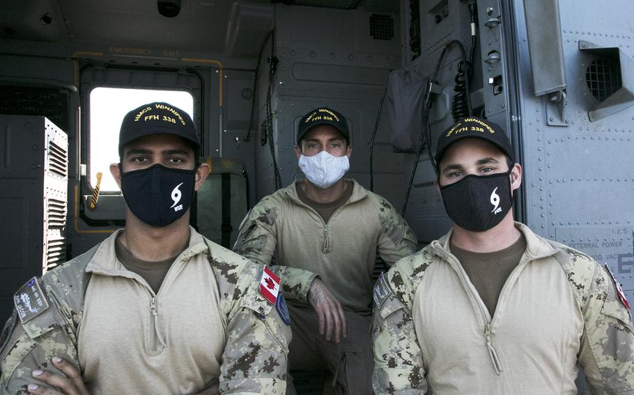 The crew of a Royal Canadian Air Force CH-148 Cyclone helicopter pose aboard the HMCS Winnipeg at White Beach Naval Facility, Okinawa, Monday, Nov. 15, 2021. 