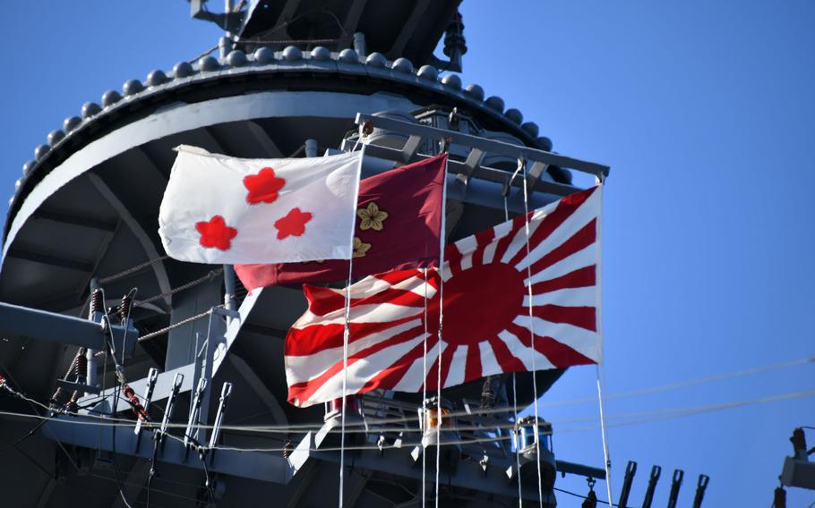 A “rising sun” flag, right, flies from a Japan Maritime Self-Defense Force vessel during the Japan International Fleet Review in Sagami Bay, Japan, on Nov. 7, 2022.