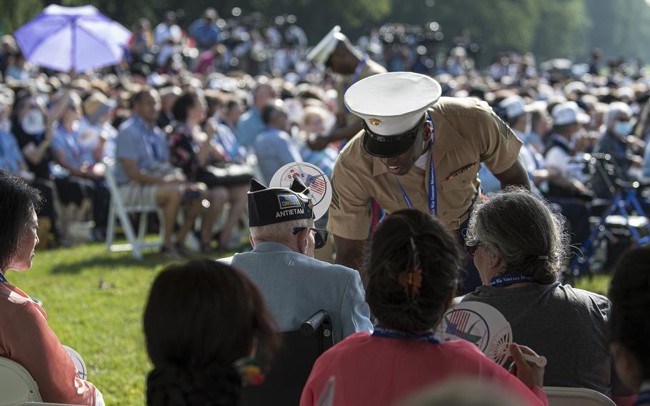 A U.S. Marine offers cold water to a Korean War veteran during a ceremony to dedicate the Wall of Remembrance addition to the Korean War Memorial on the National Mall in Washington, D.C. on Wednesday, July 27, 2022.