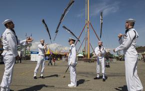 Drill team members toss their guns in the air.