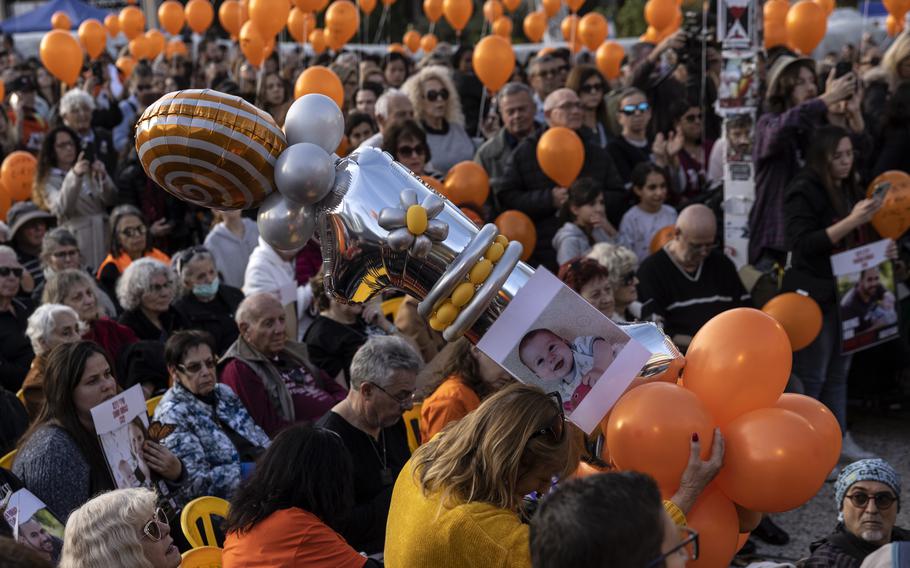 Demonstrators hold orange balloons during a rally in Tel Aviv for Kfir Bibas, an Israeli toddler taken hostage on Oct. 7, on his first birthday Thursday, Jan. 18, 2024.