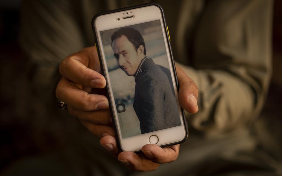 Amal Ahmadi, 32, holds a picture of his slain brother Zemerai Ahmadi at the family house in Kabul, Afghanistan, on Monday, Sept. 13, 2021.