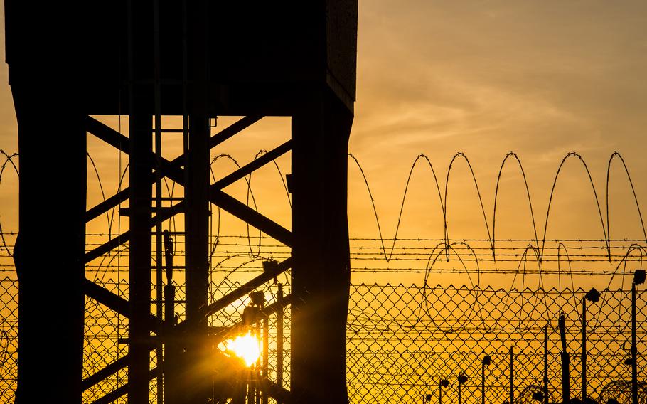 The rising sun silhouettes an out-of-use guard tower, fence and concertina wire at Camp Delta in Guantanamo Bay, Cuba on April 19, 2016. 