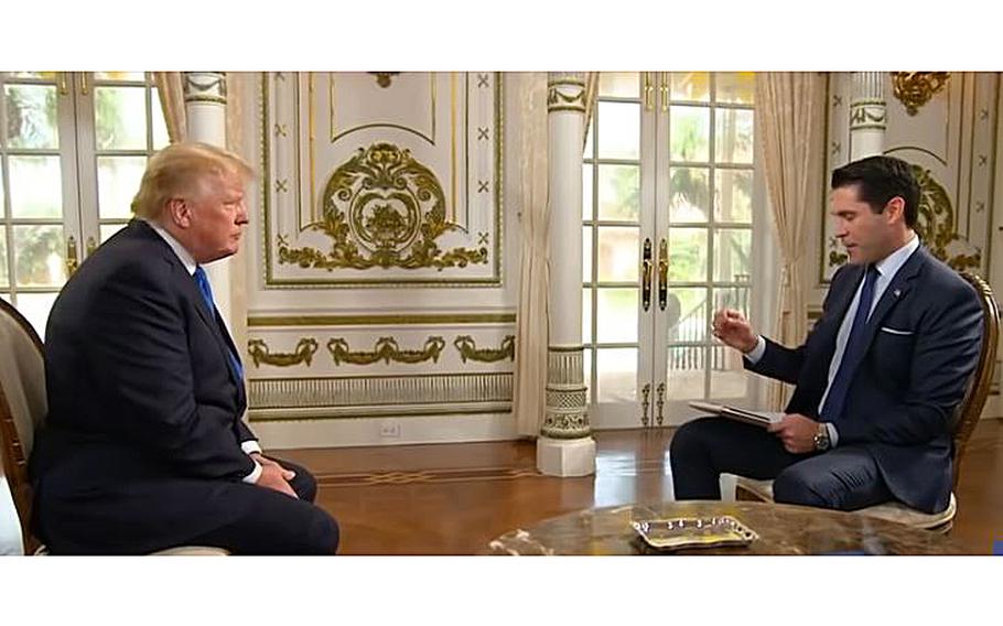 A video screen grab shows former President Donald Trump listening to a question from Newsmax host Rob Schmitt.
