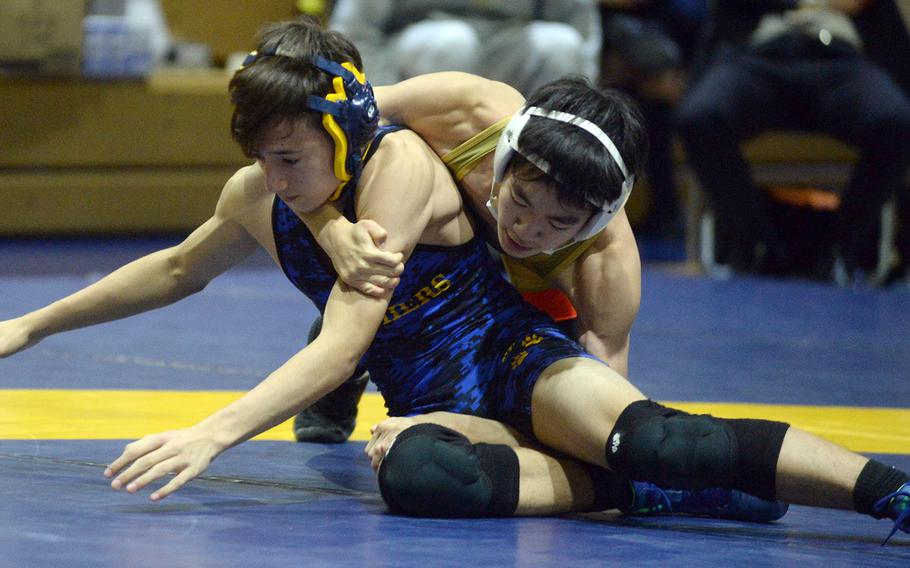 Yokota's Julian Chuckrey tries to evade St. Mary's Jong In Lee at 115 pounds during Wednesday's Kanto Plain wrestling dual meet. Lee won by technical fall 14-4 in 4 minutes, 58 seconds and the Titans won the meet 46-5.