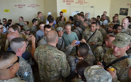 Jon Stewart, host of Comedy Central's "The Daily Show," is surrounded by soldiers of the 3rd Brigade Combat Team, 1st Infantry Division, Task Force Duke, during a USO tour to Forward Operating Base Salerno July 31. Stewart, along with NBA All-Star Karl Malone and street illusionist David Blaine, visited the FOB for a few hours as part of a USO tour to improve morale for deployed troops.