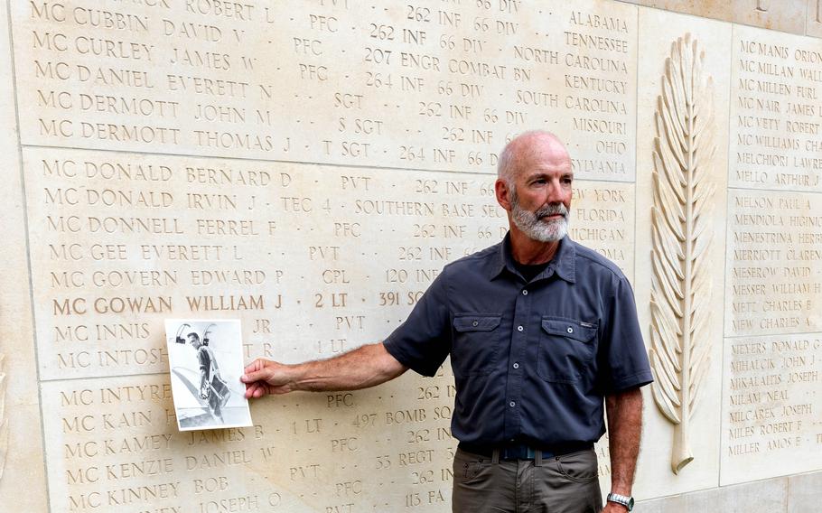 Paul Stouffer, U.S. Army Air Force 2nd Lt. William J. McGowan's nephew, poses with a photo of his uncle at the Wall of the Missing at Normandy American Cemetery, France, July 8, 2022, nearly 80 years after McGowan was killed during operations in France during World War II.  Prior to his identification and burial, McGowans name was recorded on the Walls of the Missing, which features the inscribed names of about 1,600 people. A rosette was placed next to his name after the ceremony to indicate he has now been accounted for.