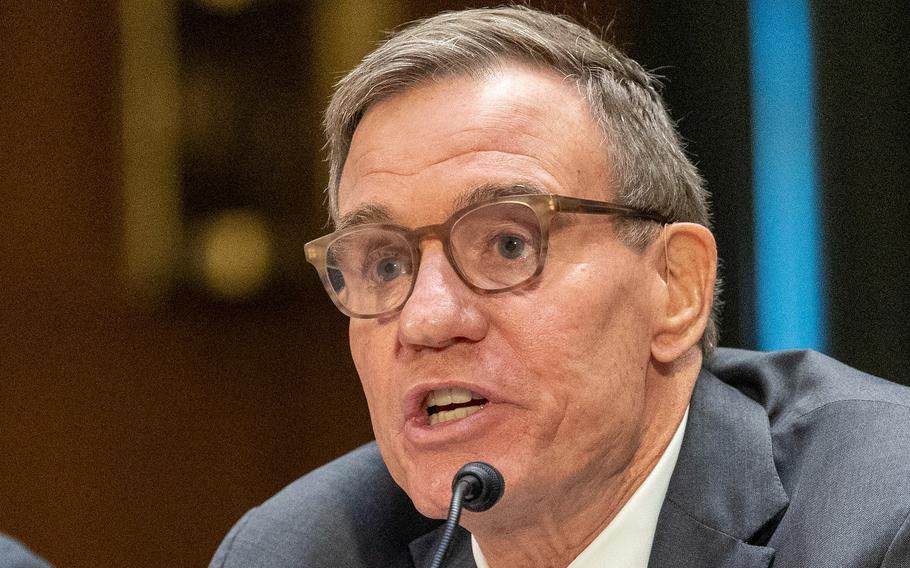 Warner speaks into a microphone.