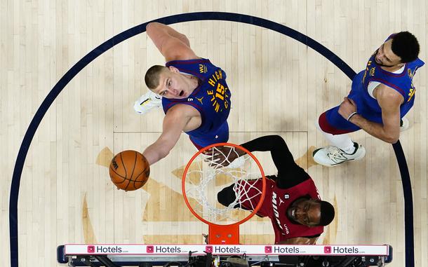 Denver Nuggets center Nikola Jokic (15) reaches for a rebound next to Miami Heat center Bam Adebayo during the second half of Game 1 of basketball's NBA Finals, Thursday, June 1, 2023, in Denver. (AP Photo/Jack Dempsey, Pool)